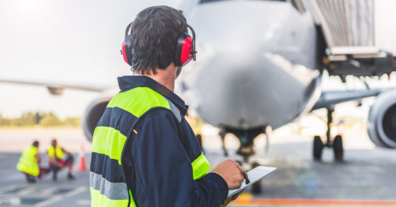 Male worker controlling aircraft and writing information